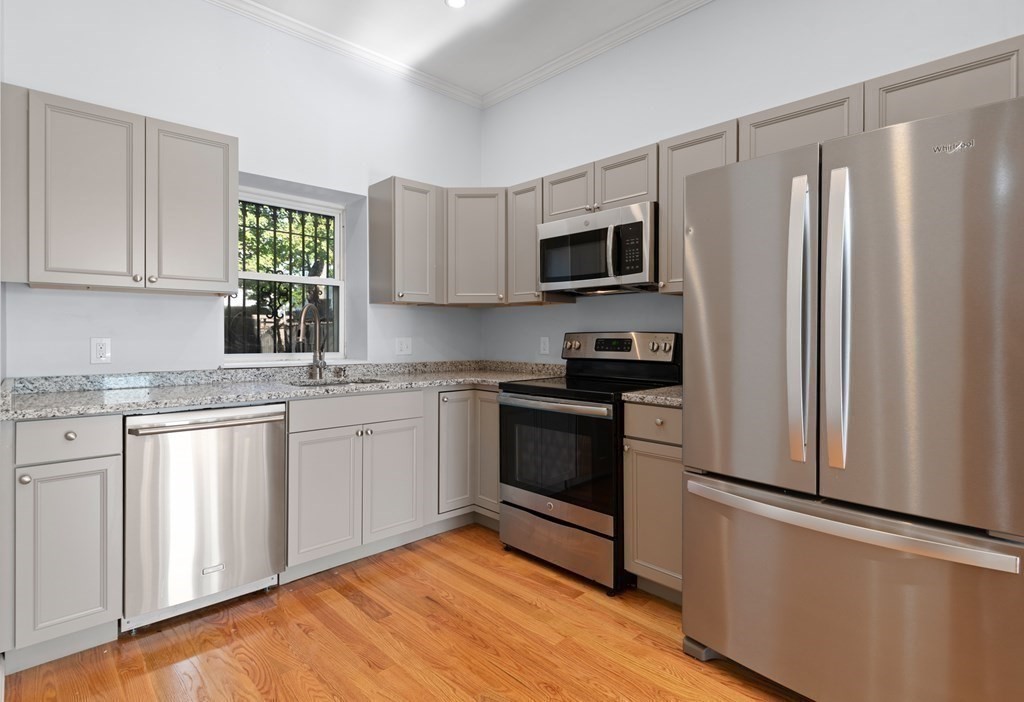 2 Woodbine Street, Unit 1 Boston, MA 02119 - Photo 5 of 20 a kitchen with stainless steel appliances granite countertop a refrigerator sink and microwave