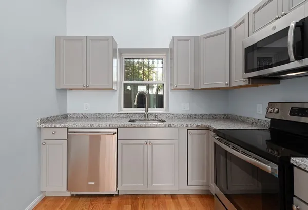a kitchen with stainless steel appliances granite countertop a stove a sink and a microwave