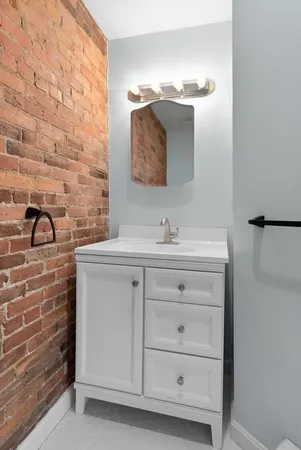 a bathroom with a sink vanity and mirror