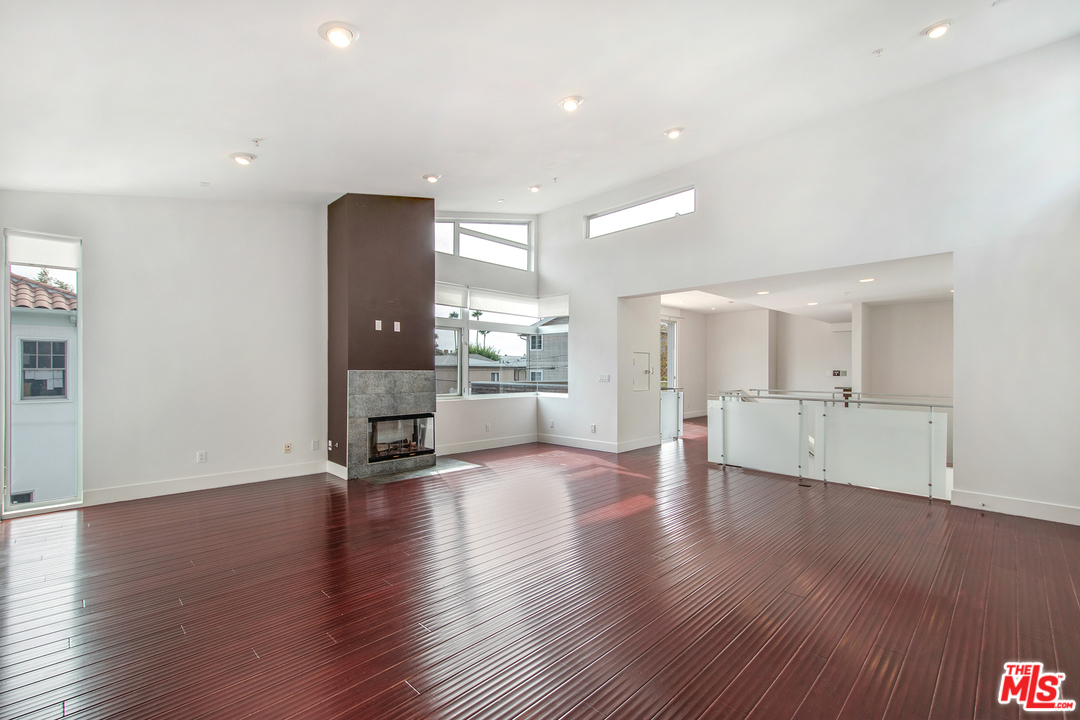 717 South Broadway, Unit B Redondo Beach, CA 90277 - Photo 18 of 29 a view of an empty room with wooden floor and a kitchen