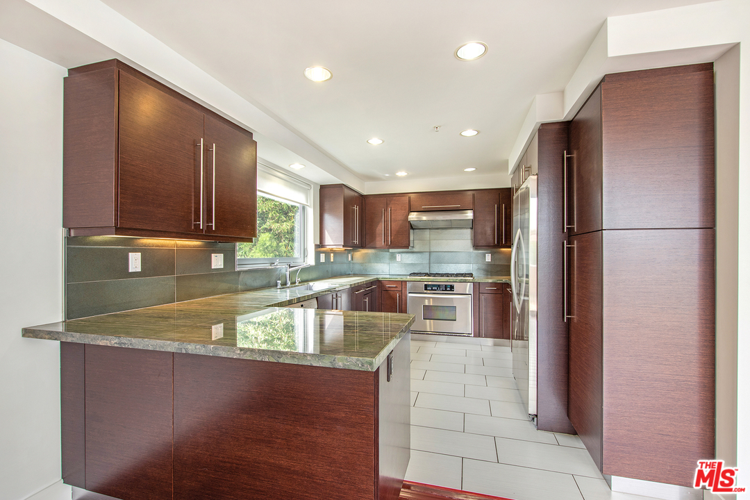 717 South Broadway, Unit B Redondo Beach, CA 90277 - Photo 23 of 29 a large kitchen with a large counter top stainless steel appliances and cabinets
