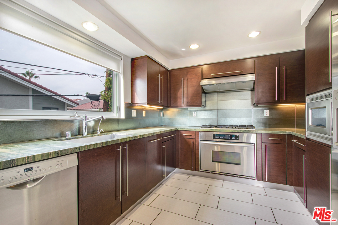 717 South Broadway, Unit B Redondo Beach, CA 90277 - Photo 24 of 29 a kitchen with stainless steel appliances granite countertop a sink stove and refrigerator