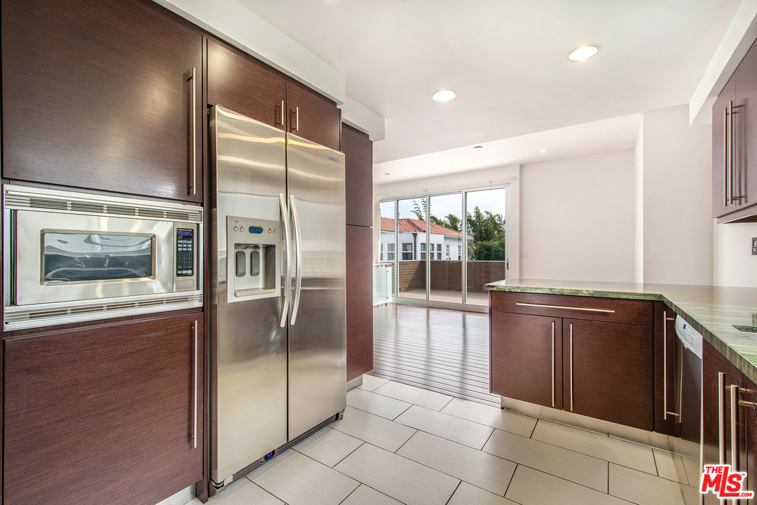 717 South Broadway, Unit B Redondo Beach, CA 90277 - Photo 25 of 29 a open kitchen with stainless steel appliances granite countertop a refrigerator and a sink