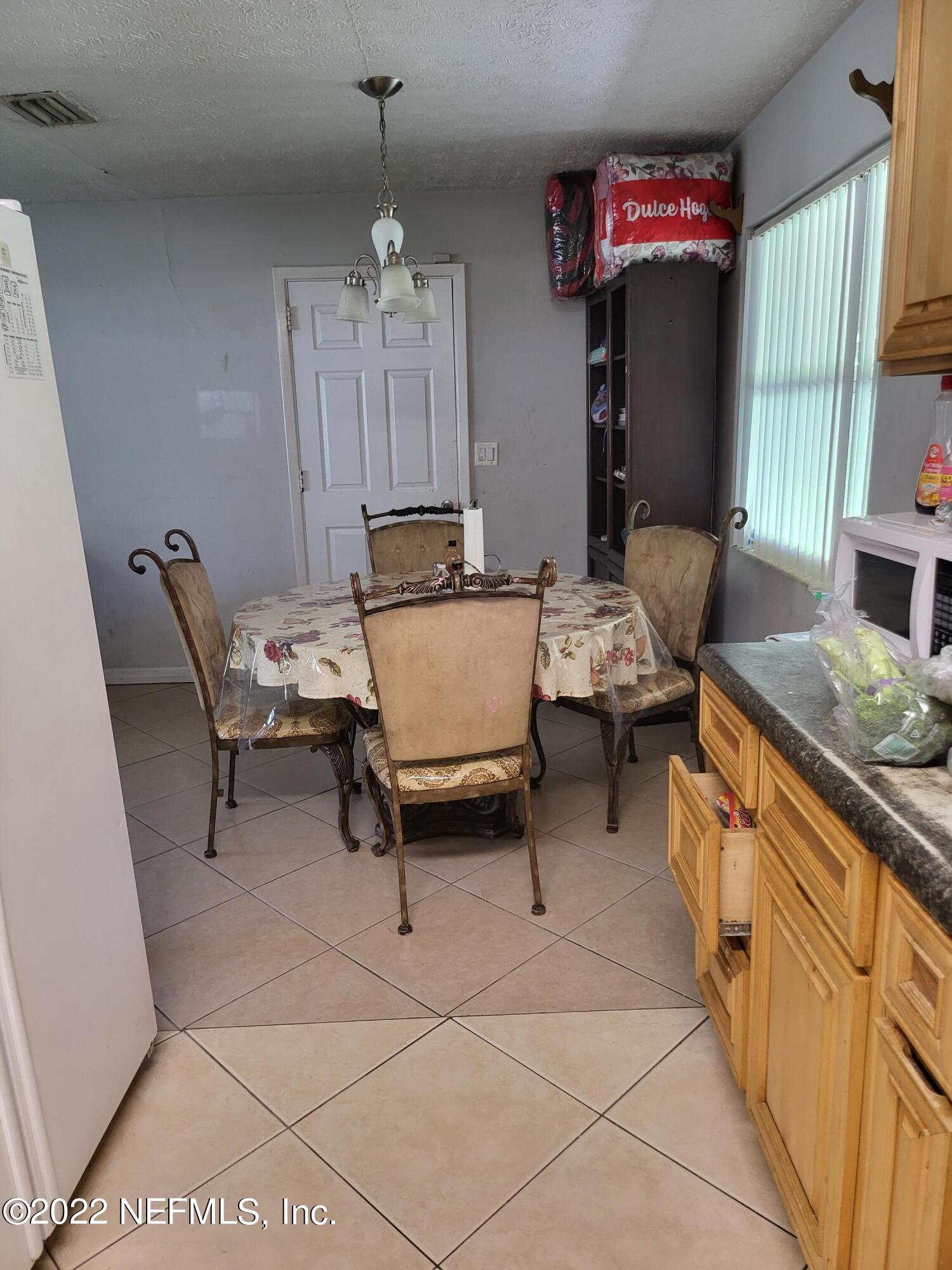 2529 Sam Road Jacksonville, FL 32216 - Photo 2 of 12 a living room with furniture a dining table and a fireplace