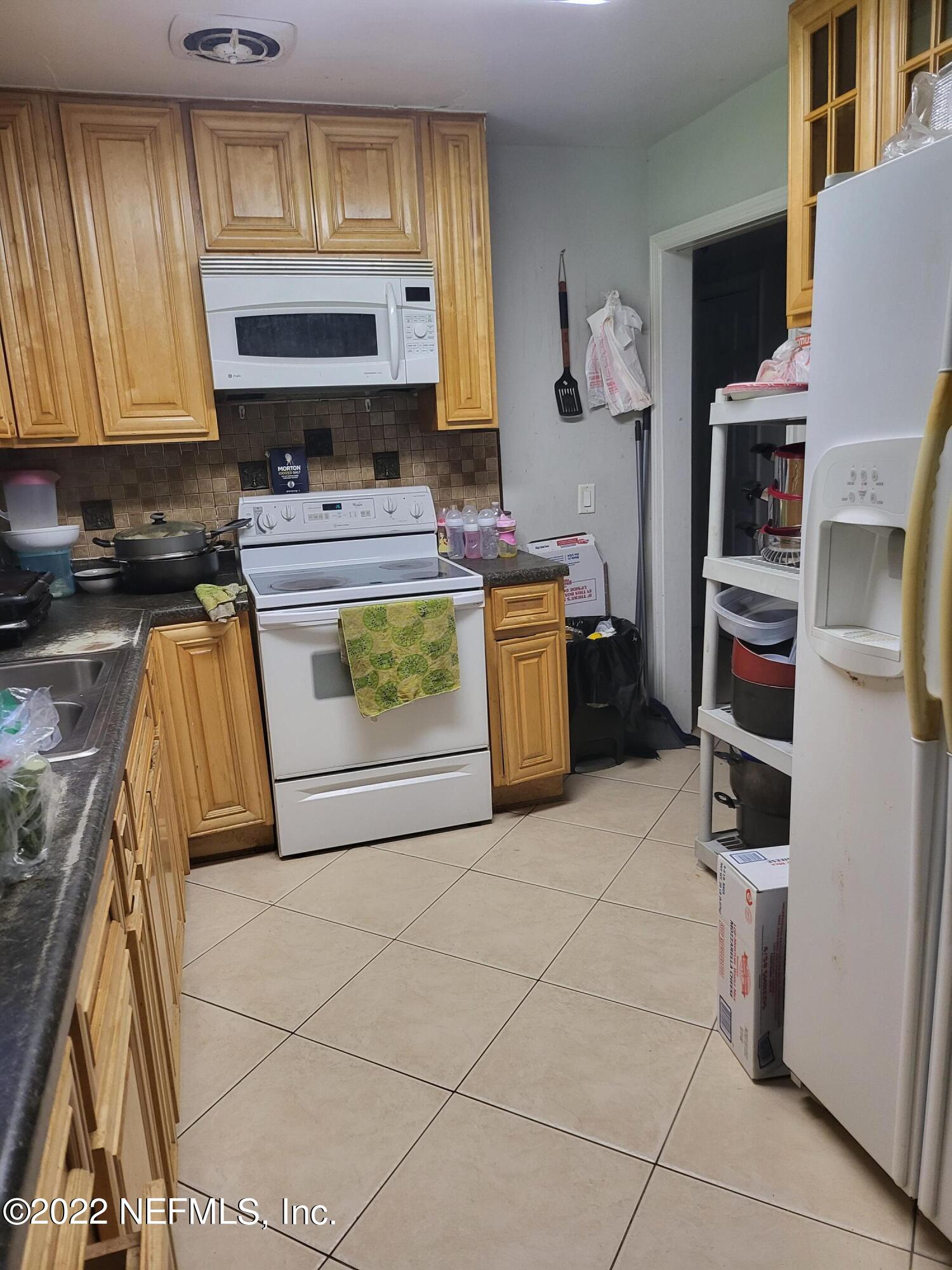 2529 Sam Road Jacksonville, FL 32216 - Photo 4 of 12 a kitchen with stainless steel appliances granite countertop a stove a sink and a microwave