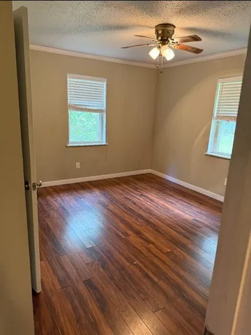 a view of empty room with wooden floor