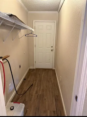a view of a room with wooden floor and white walls