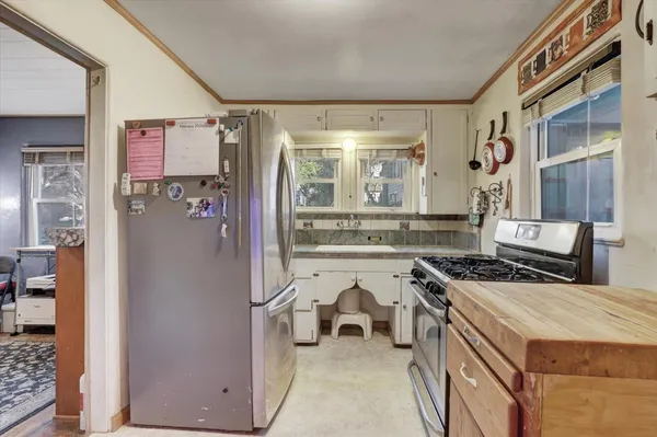 a white stove top oven sitting inside of a kitchen