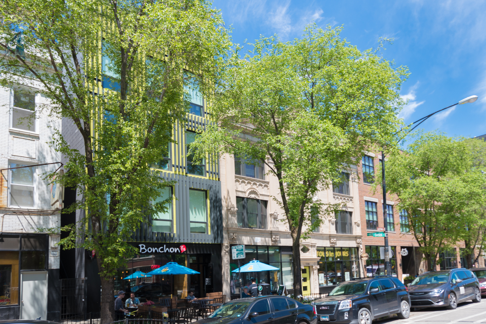 a street sign on a city street lined with buildings and cars