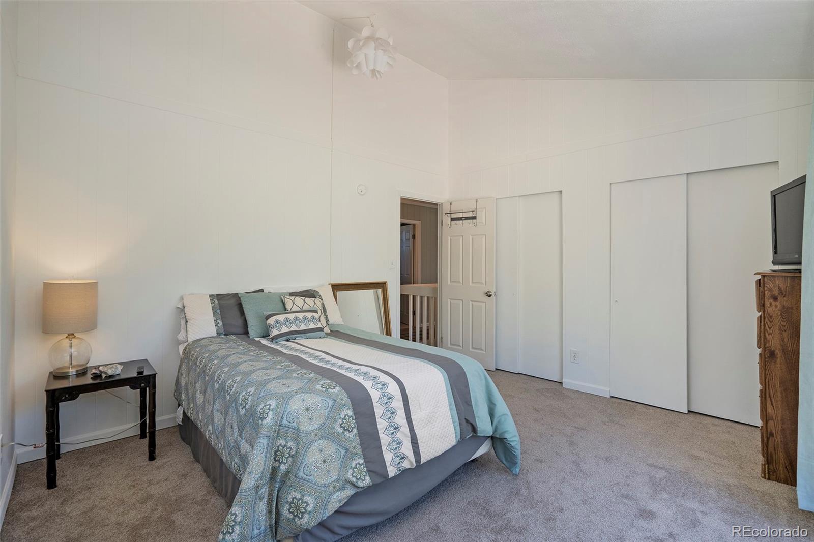 249 Burland Drive Bailey, CO 80421 - Photo 13 of 24 a bedroom with a bed and a lamp