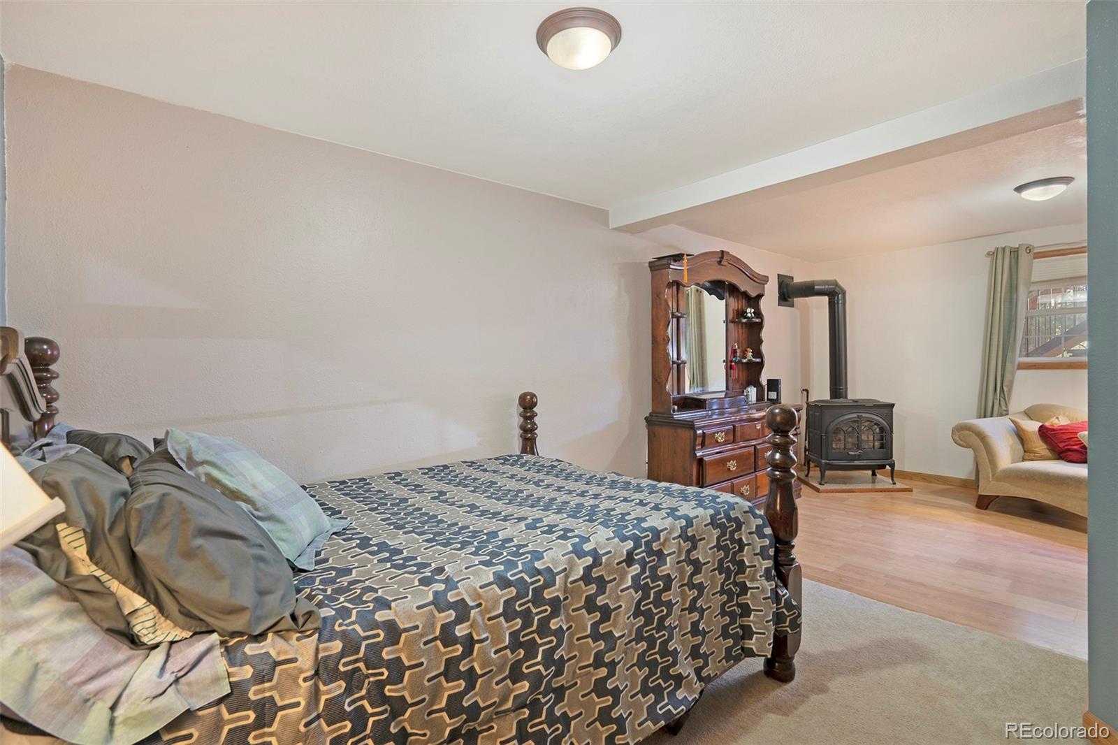 249 Burland Drive Bailey, CO 80421 - Photo 16 of 24 a bedroom with a bed and chair