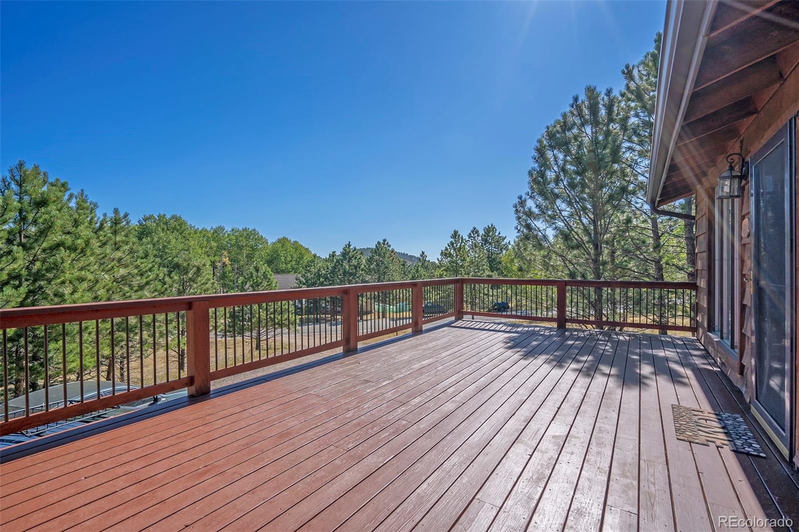 249 Burland Drive Bailey, CO 80421 - Photo 21 of 24 a view of roof deck with wooden floor and fence with a large window