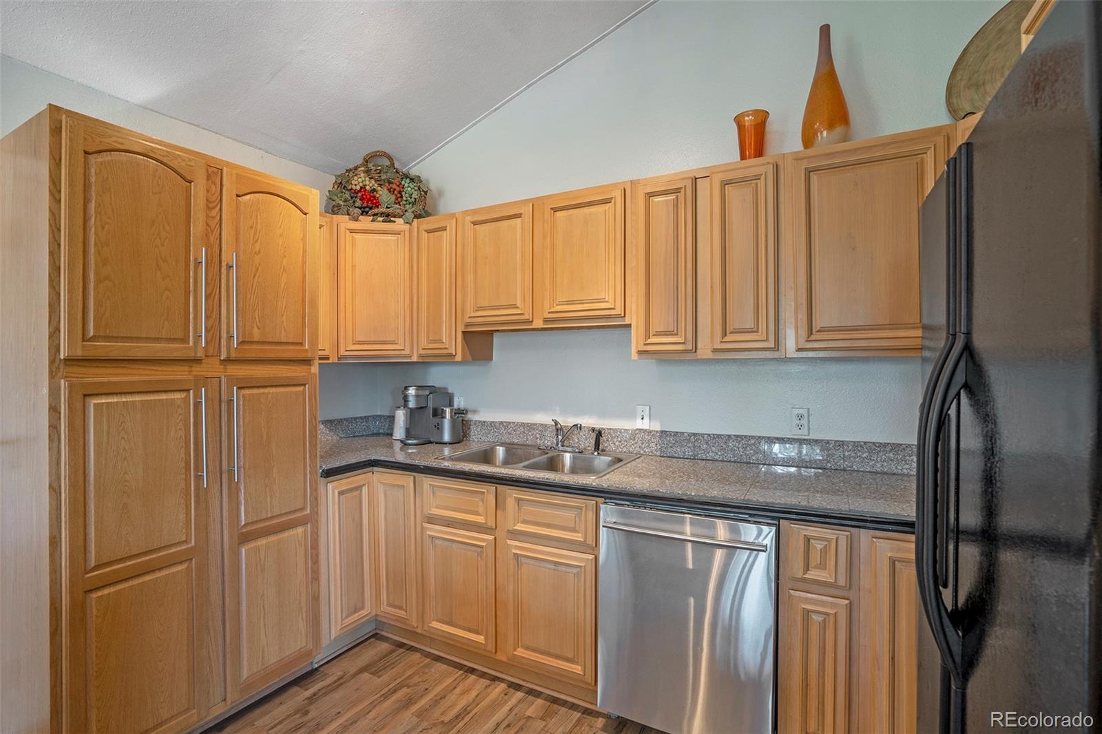 249 Burland Drive Bailey, CO 80421 - Photo 7 of 24 a kitchen with stainless steel appliances granite countertop a refrigerator sink and cabinets