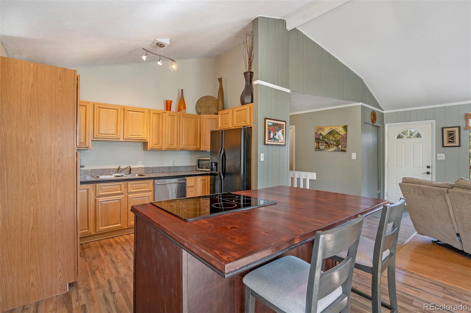 249 Burland Drive Bailey, CO 80421 - Photo 9 of 24 a kitchen with stainless steel appliances granite countertop a kitchen island a stove a table and chairs