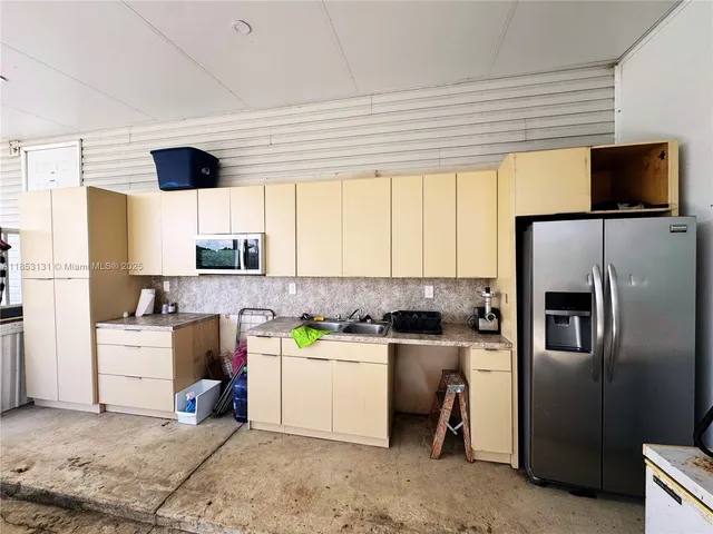 a couple of chairs sitting in big yard with large trees