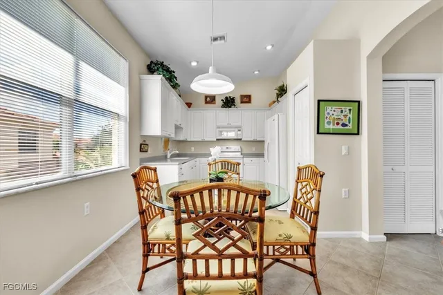 a kitchen with granite countertop white cabinets and white appliances
