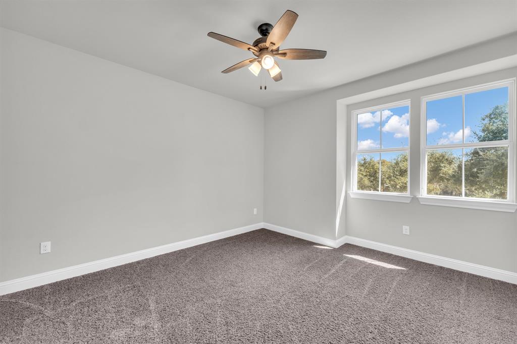 110 Magona Trail Georgetown, TX 78628 - Photo 23 of 38 An airy bedroom with dual windows and a ceiling fan, offering a serene, private view.