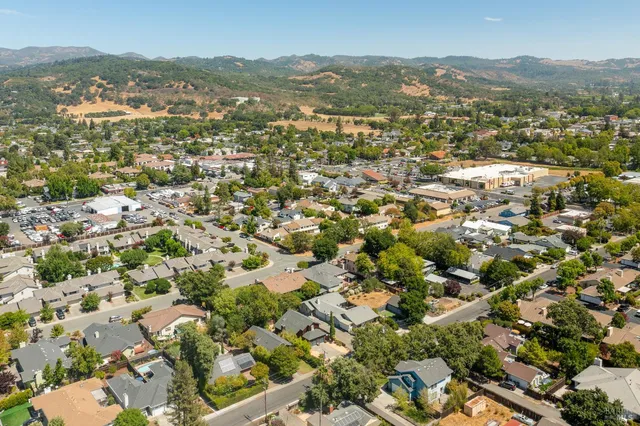 an aerial view of residential houses with outdoor space and trees
