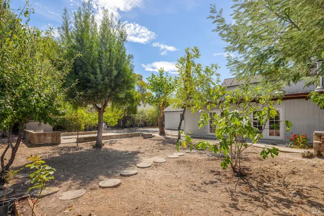 a backyard of a house with table and chairs