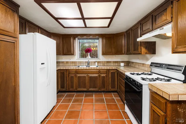 a kitchen with stainless steel appliances granite countertop a stove and a sink