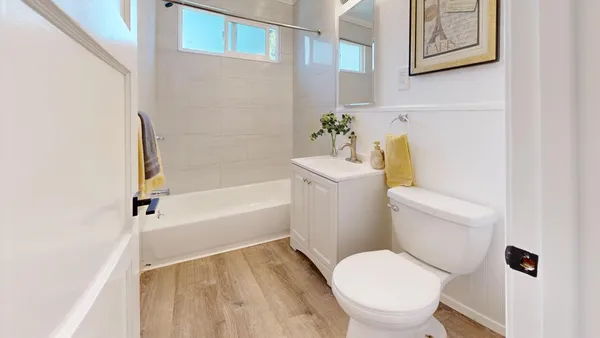 a white toilet sitting next to a bath tub
