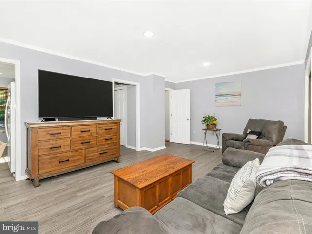 a view of a hallway with wooden floor and cabinet
