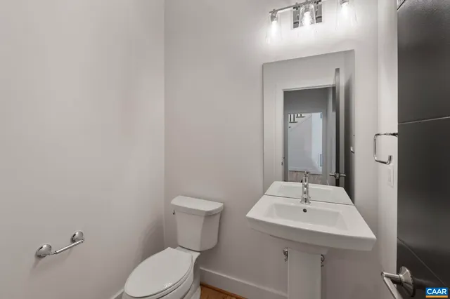 a bathroom with a sink toilet and mirror