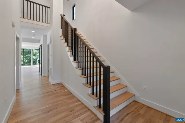 a view of staircase with wooden floor and white walls