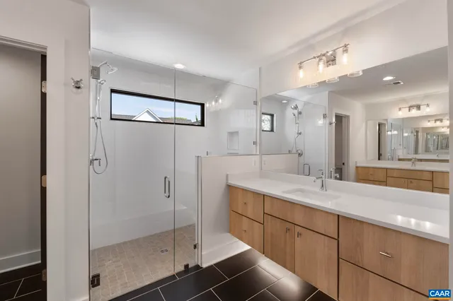 a bathroom with a shower sink and mirror