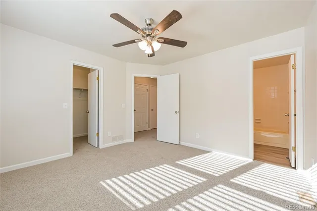 a view of a livingroom with a ceiling fan and wooden floor