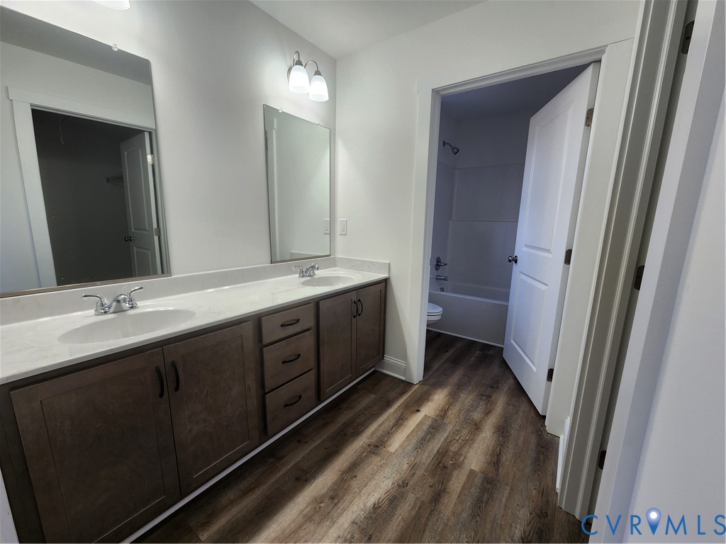 2545 Wickham Road Bumpass, VA 23024 - Photo 17 of 23 a spacious bathroom with a double vanity sink a toilet and a mirror