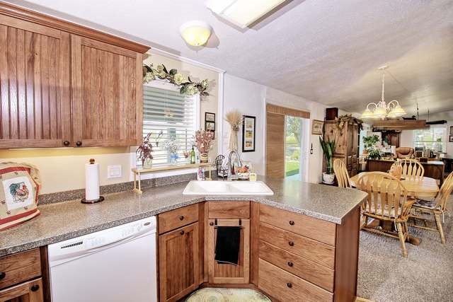 2135 M Road Grand Junction, CO 81505 - Photo 34 of 42 a kitchen with granite countertop a sink a stove cabinets dining table and chairs