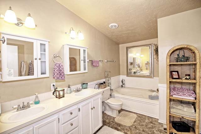 2135 M Road Grand Junction, CO 81505 - Photo 40 of 42 a bathroom with a granite countertop sink mirror vanity bathtub and a toilet