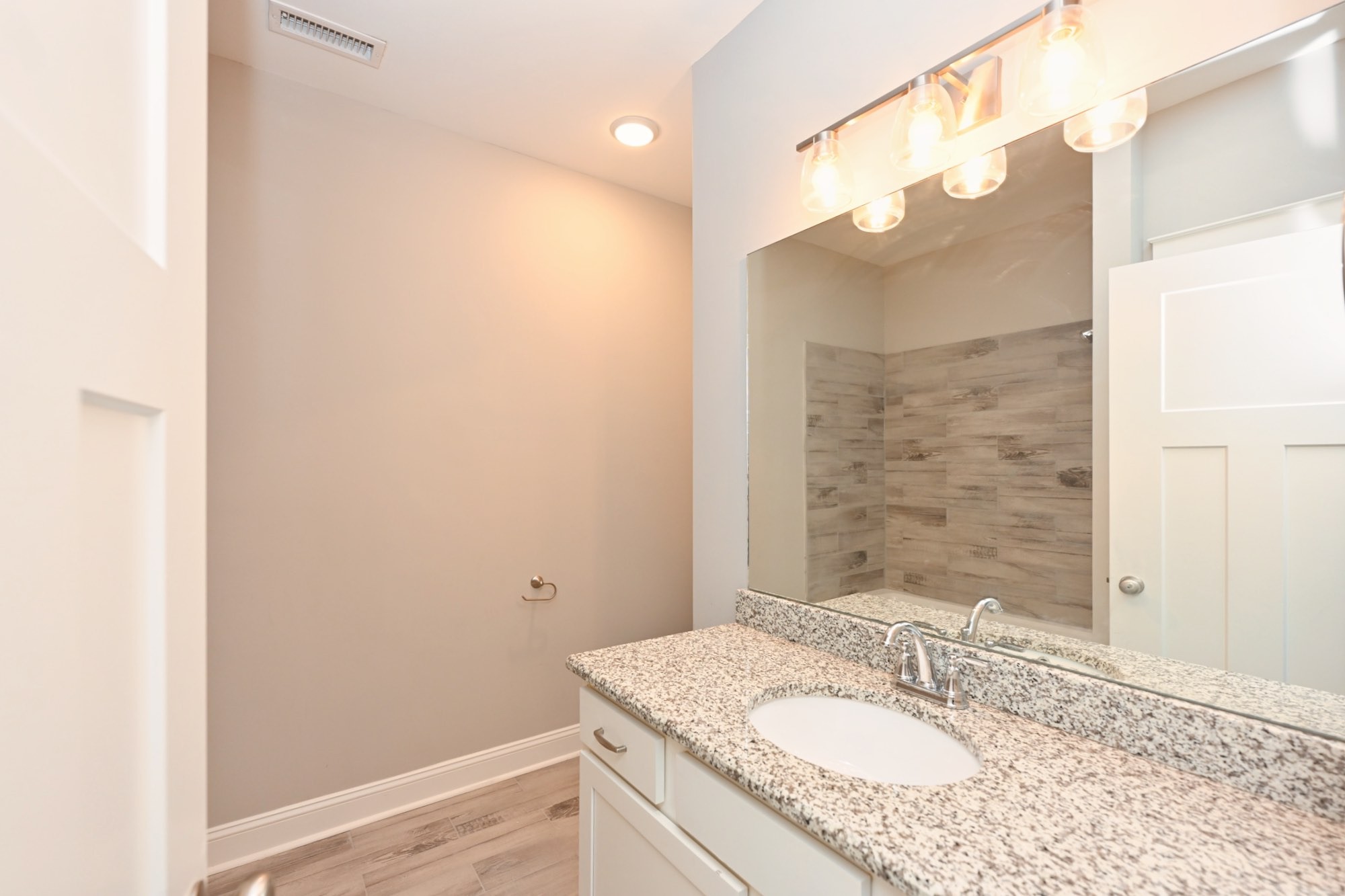 1019 North Maple Street, Unit 2D Murfreesboro, TN 37130 - Photo 36 of 56 a bathroom with a granite countertop sink a mirror and a shower