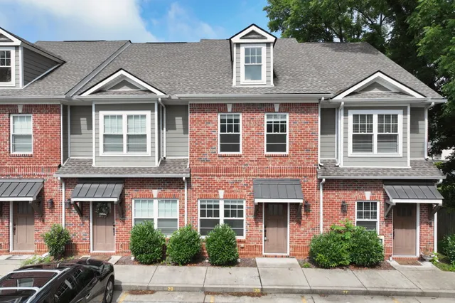a front view of a house with a yard and trees