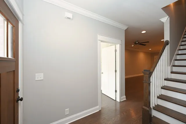a view of a hallway with wooden floor and staircase