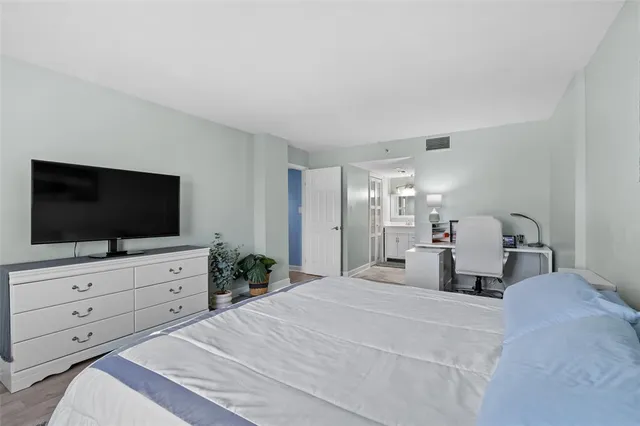 a bedroom with a bed and a flat screen tv