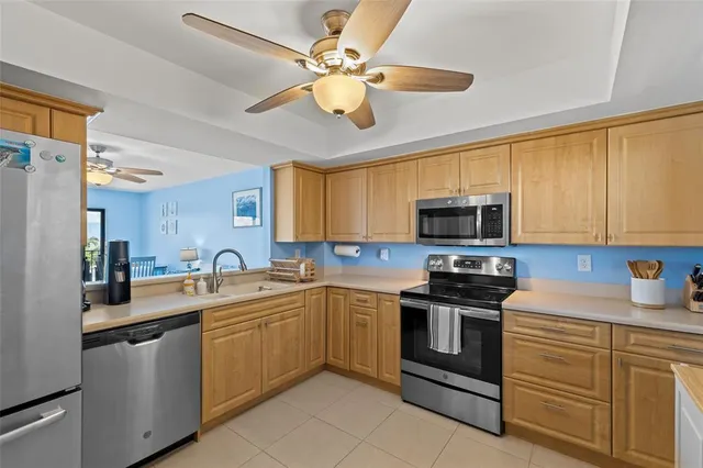 a kitchen with stainless steel appliances granite countertop a sink a stove cabinets and a refrigerator