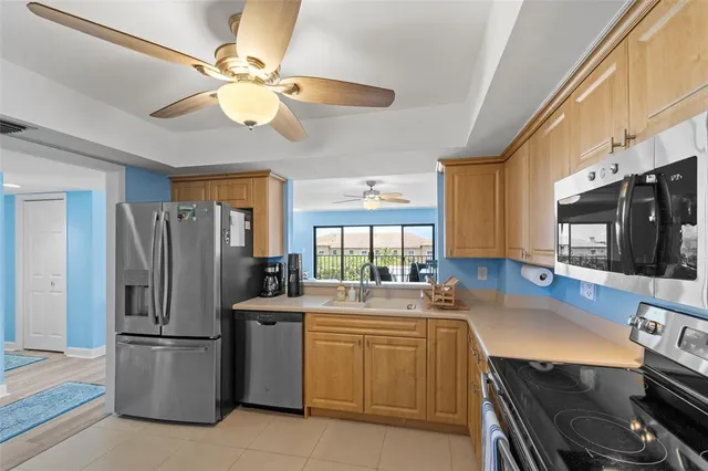 a kitchen with stainless steel appliances a refrigerator a stove a sink and white cabinets