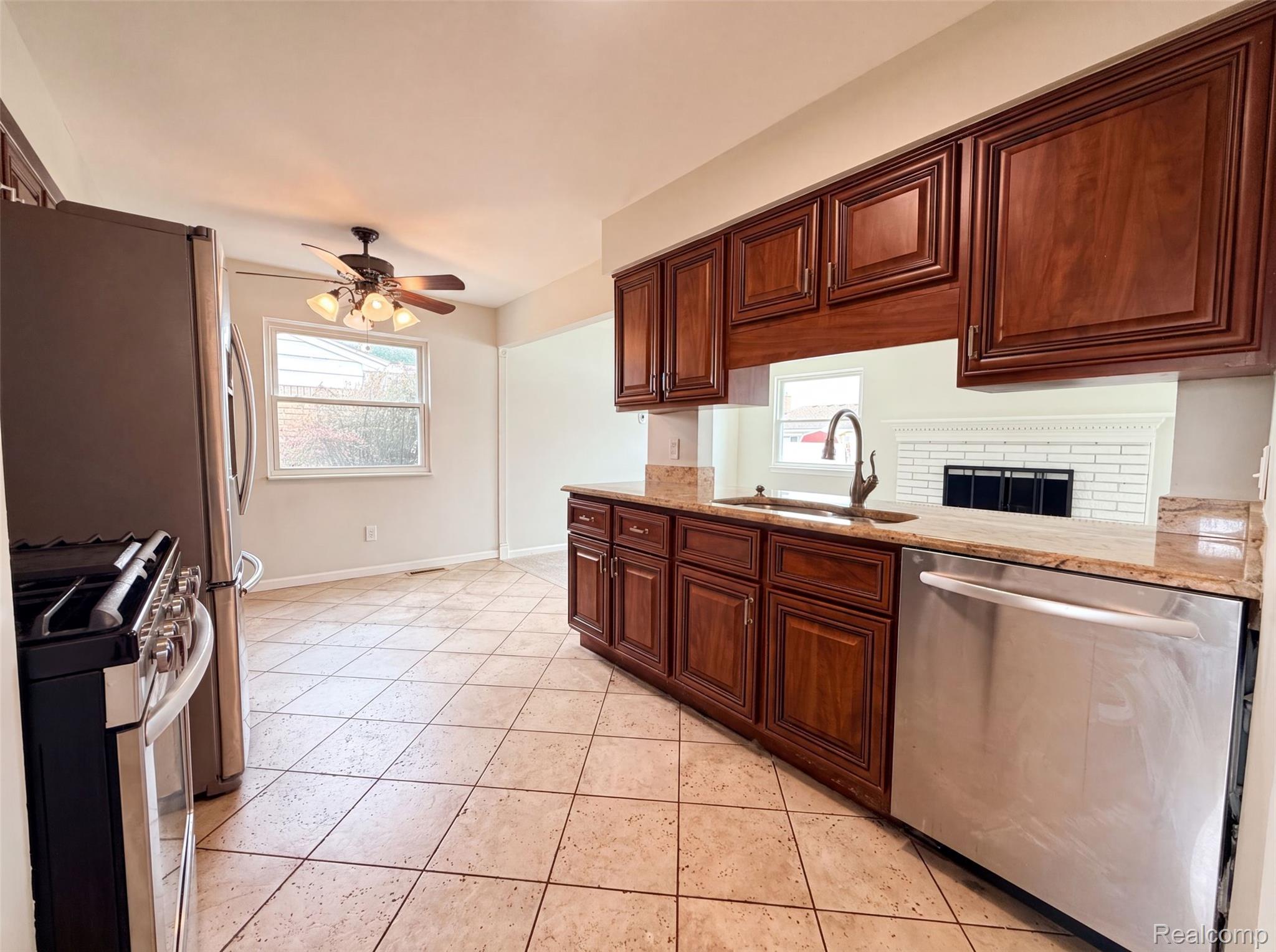 14729 Moran Road Allen Park, MI 48101 - Photo 6 of 17 Kitchen featuring rich wood cabinetry, stone countertops, stainless steel appliances, and tile flooring