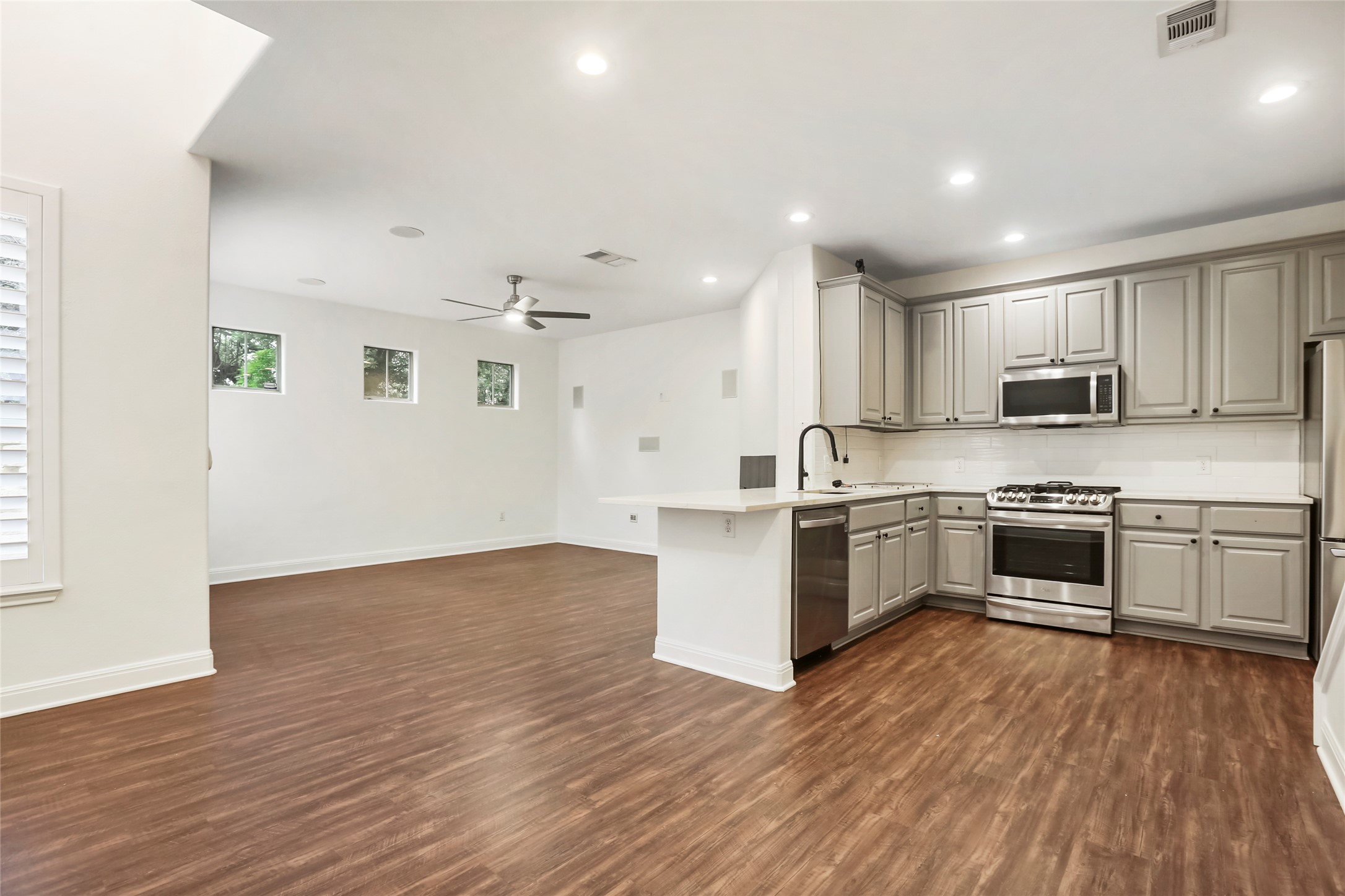3406 Menchaca Road, Unit 19 Austin, TX 78704 - Photo 8 of 25 Gleaming wood-look floors unite this airy open layout connecting the kitchen and living areas.