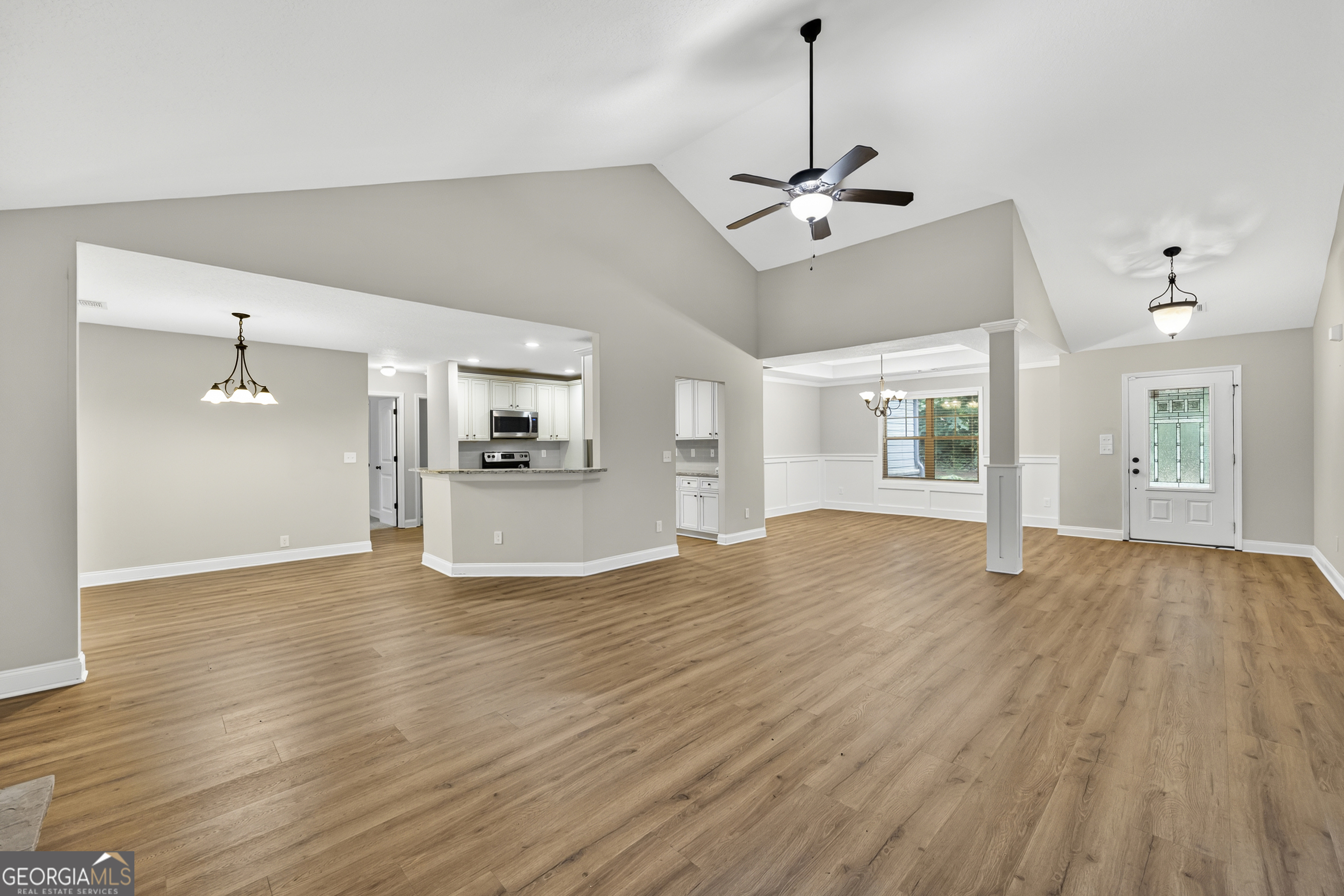 717 Oconee Lane Commerce, GA 30529 - Photo 16 of 57 a view of a room with wooden floor a ceiling fan and windows