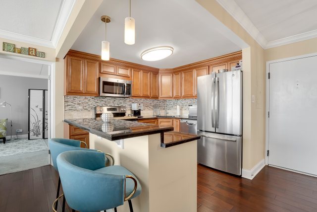 2005 South Finley Road, Unit 703 Lombard, IL 60148 - Photo 5 of 30 a kitchen with stainless steel appliances granite countertop a refrigerator a stove a sink and a microwave