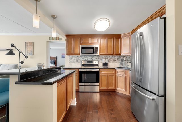 2005 South Finley Road, Unit 703 Lombard, IL 60148 - Photo 6 of 30 a kitchen with granite countertop a refrigerator stove top oven and sink