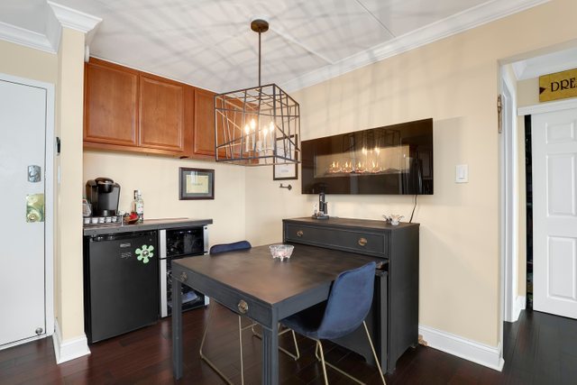 2005 South Finley Road, Unit 703 Lombard, IL 60148 - Photo 8 of 30 a kitchen with a table chairs and flat screen tv