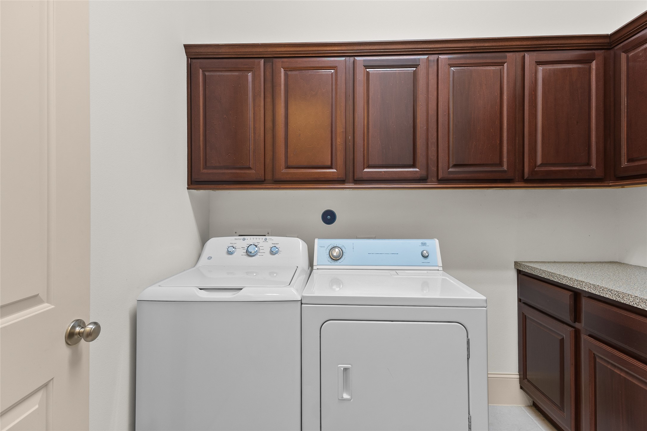 3302 Rochdale Street Houston, TX 77025 - Photo 16 of 50 This functional laundry room comes complete with built in cabinetry above and additional counter space alongside, offering plenty of room for folding and storage. Rich wood tones and a practical layout make everyday laundry tasks that much easier. It's a well organized space designed to keep things running smoothly behind the scenes.