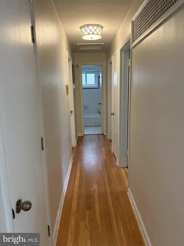 a view of a hallway with wooden floor