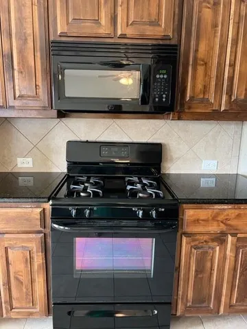 a stove top oven sitting inside of a kitchen
