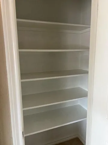 a view of walk in closet with empty racks