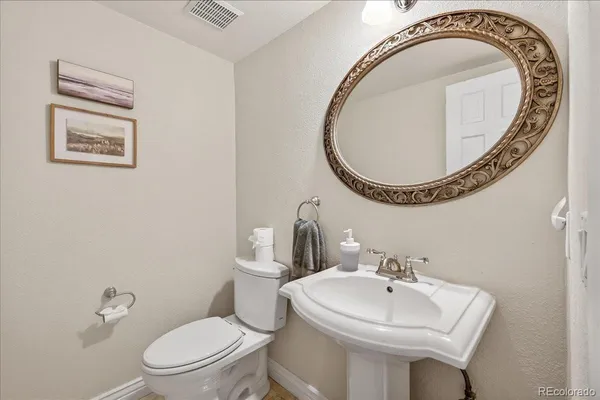 a bathroom with a toilet a sink and a mirror